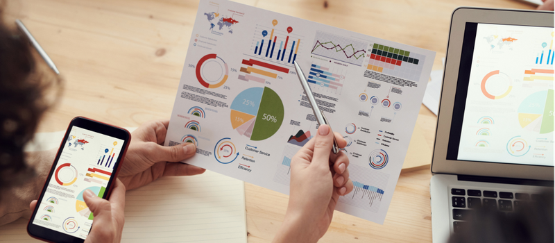 Ziergrafik: Menschen betrachten Statistiken und Visualisierungen. Der Schriftzug "Wirksamkeits- und Wirkungsanalyse" erscheint.