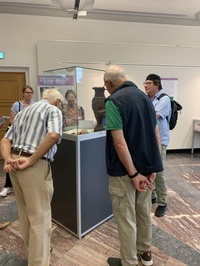 exhibition visitors looking at exhibits in a display case