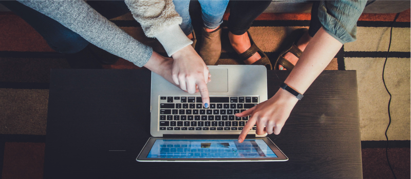 A group of people point their fingers at a laptop screen. The words "Digital Teaching Literacy" appear.